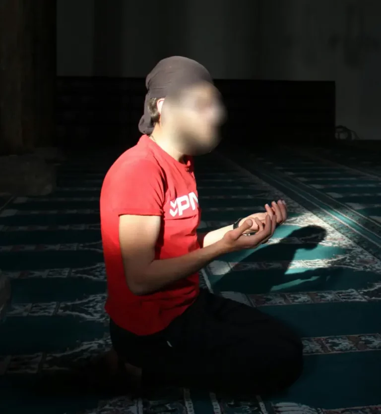 Man praying with raised hands in a moment of devotion
